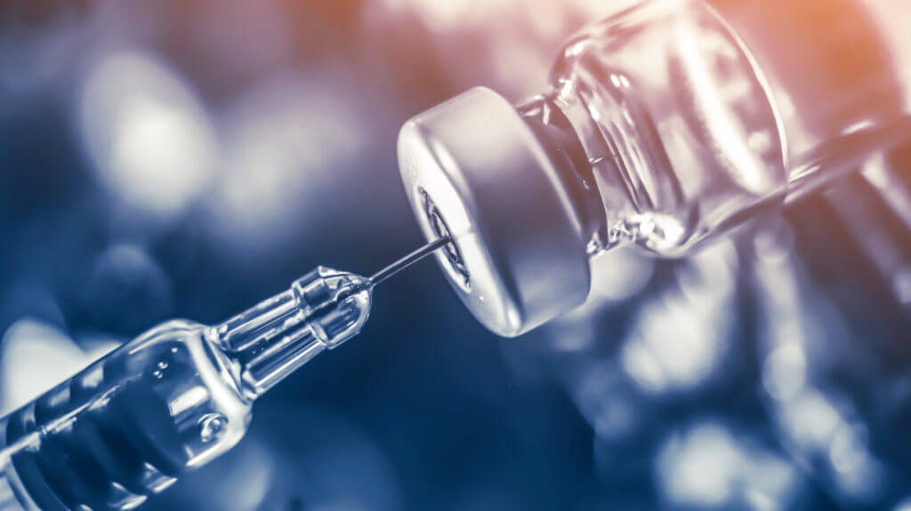 Syringe getting vaccine out of vial