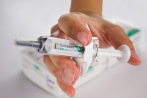 Hand holding Dupixent injection